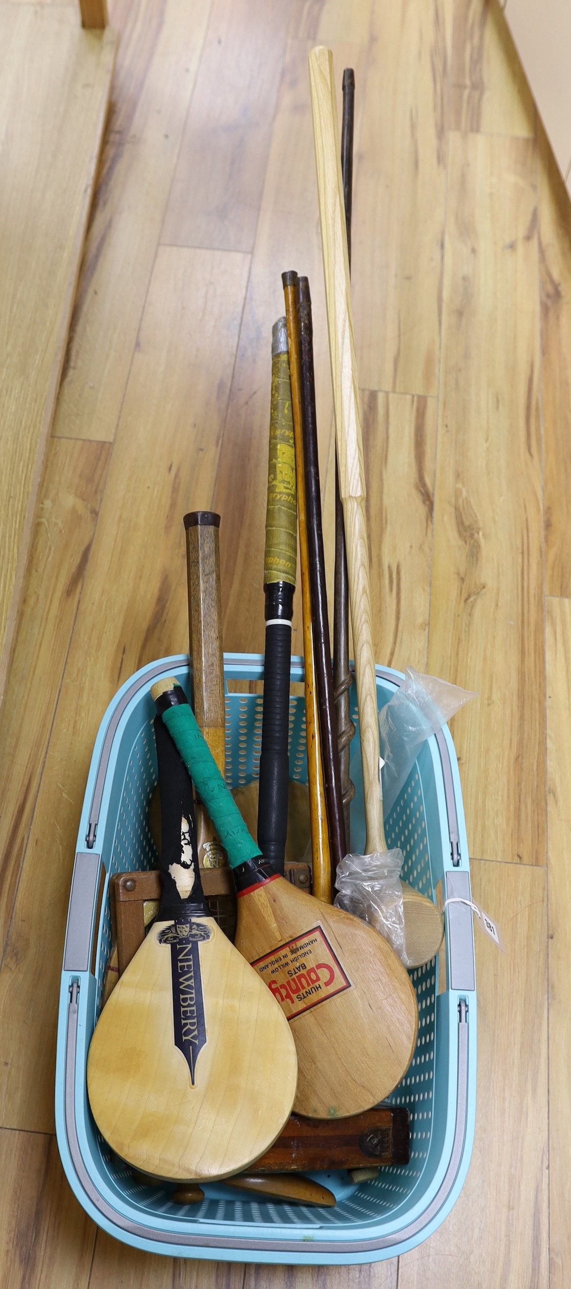 An African walking cane, two walking sticks and vintage sports equipment